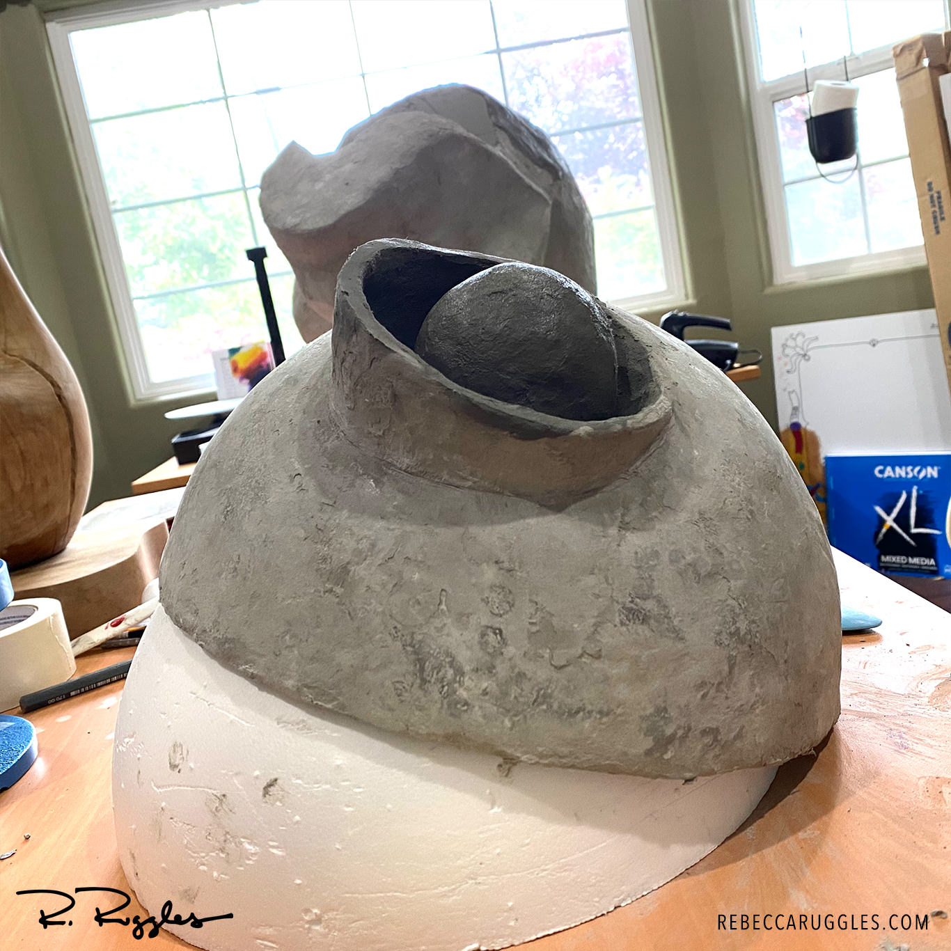 Sculpting alien face from thee molded bowls in concrete paper clay.