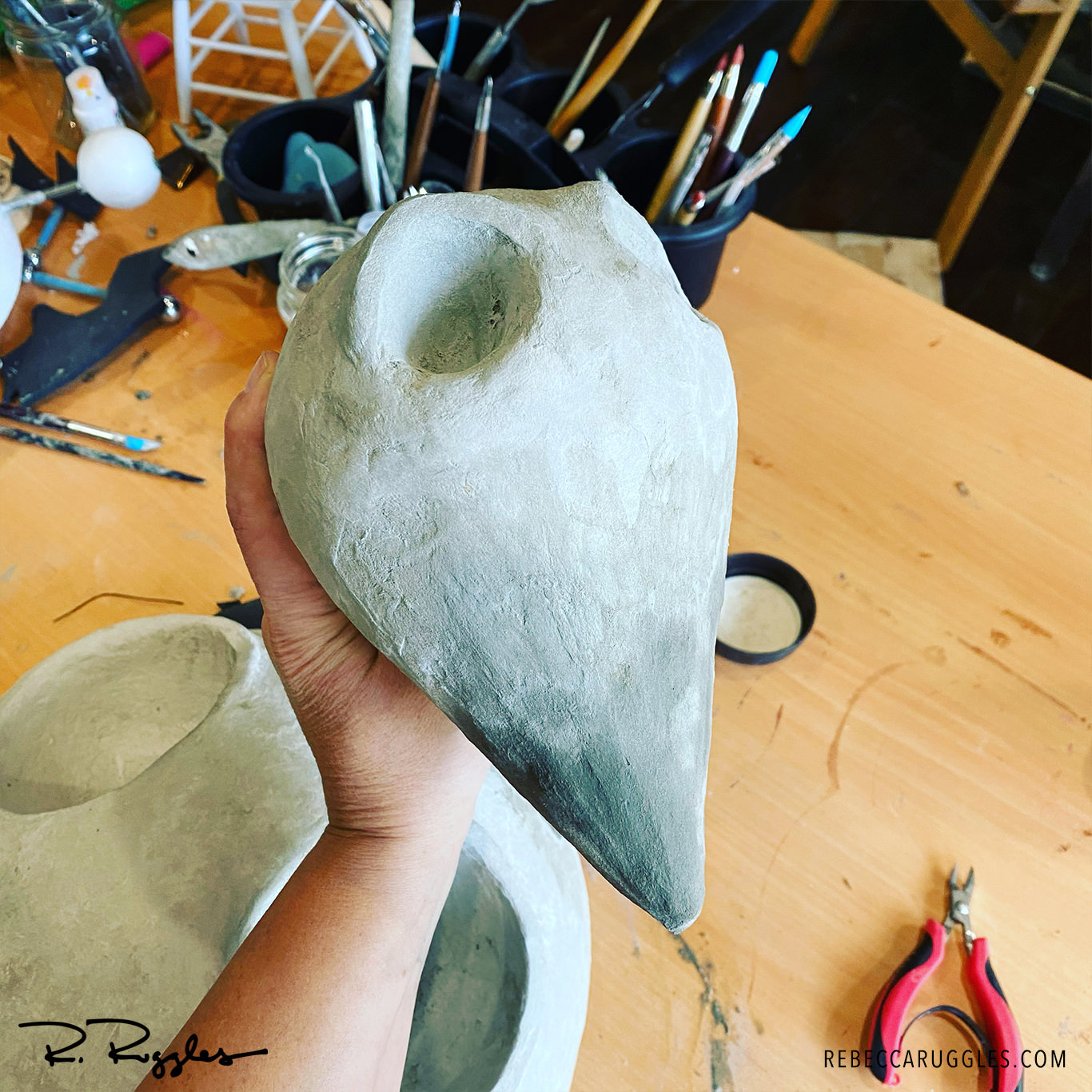 Adding eyebrows to the big bird sculpture head. Work in progress by artist Rebecca Ruggles.