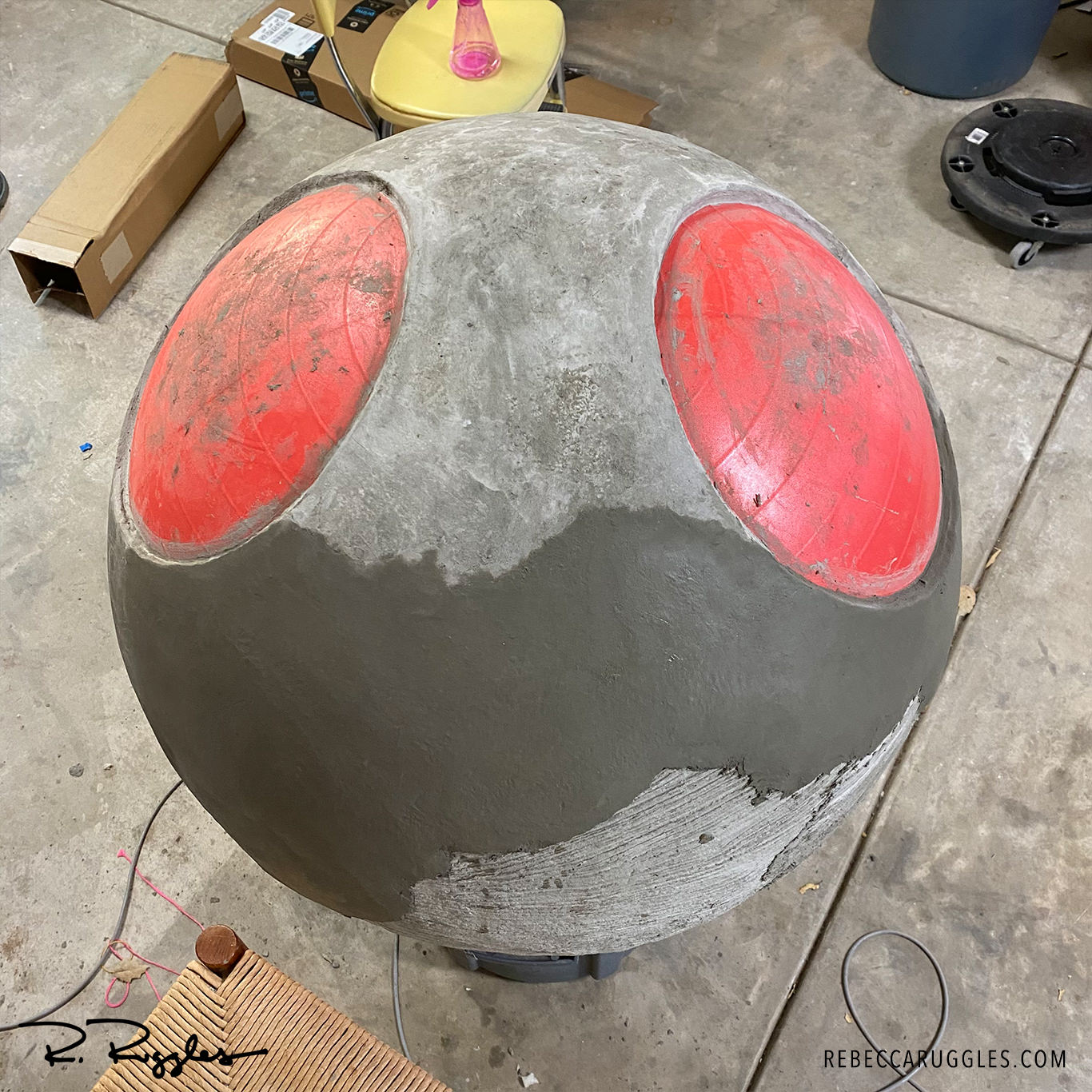 applying second coat of concrete paper clay to exercise ball form