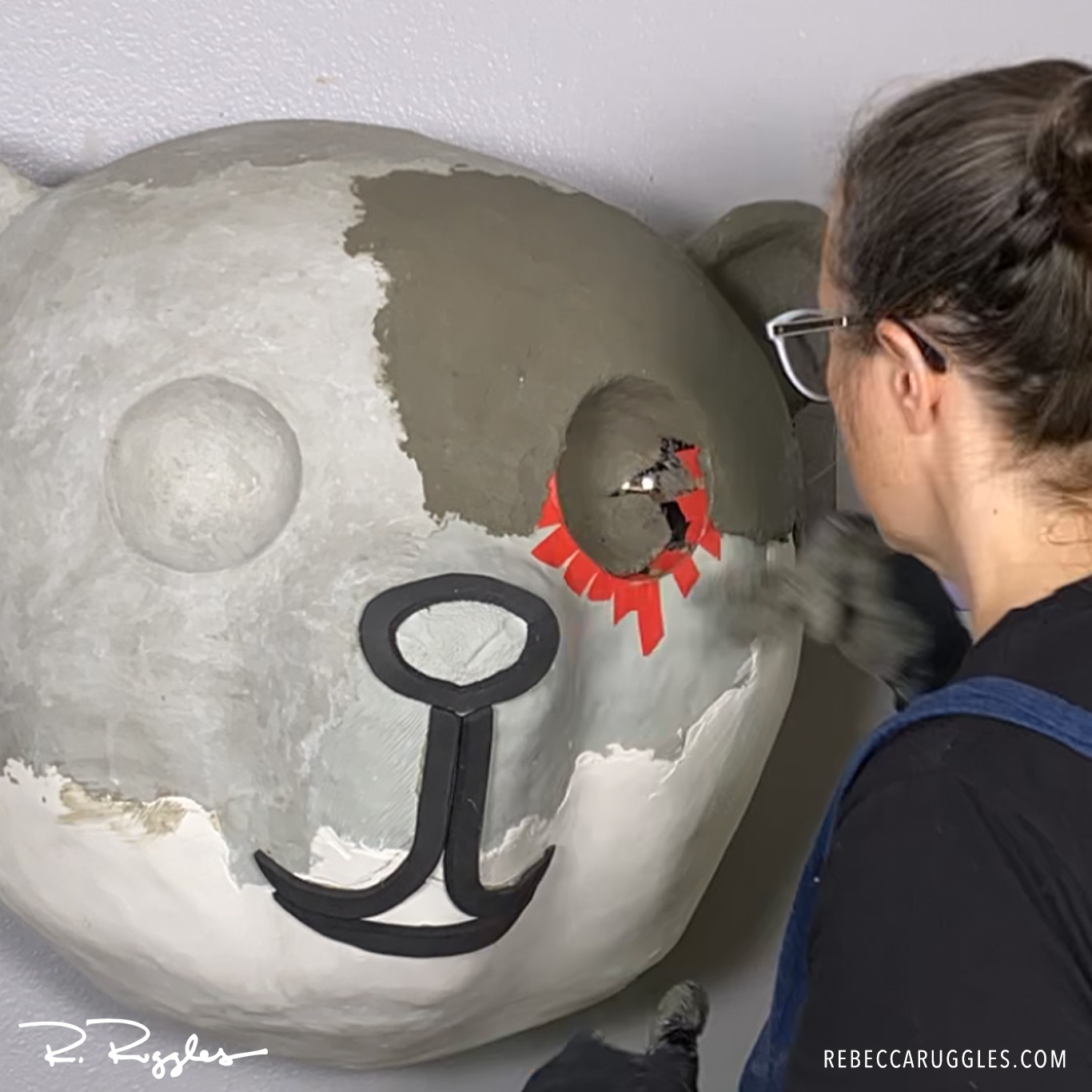 Rebecca Ruggles adding concrete clay over the panda sculpture.