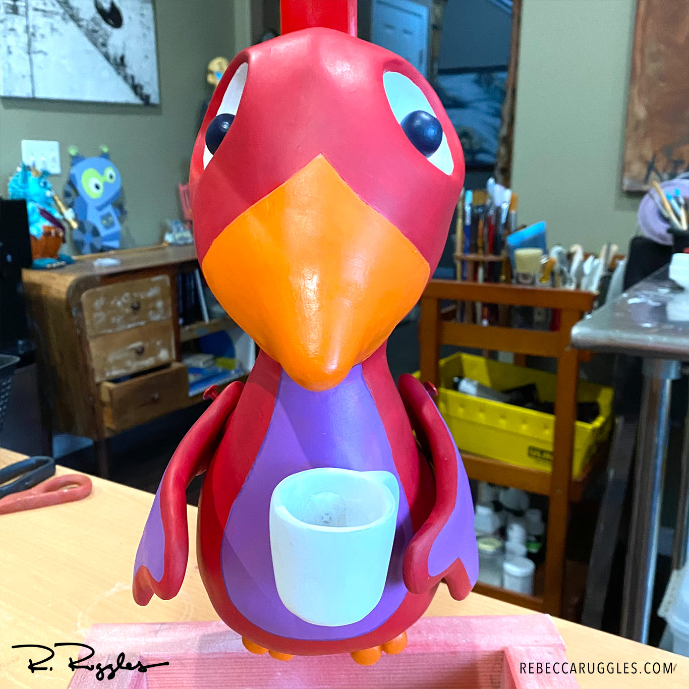 Red robin bird sculpture during painting phase.