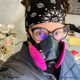 Rebecca Ruggles wearing a dust mask while working on sculpture.